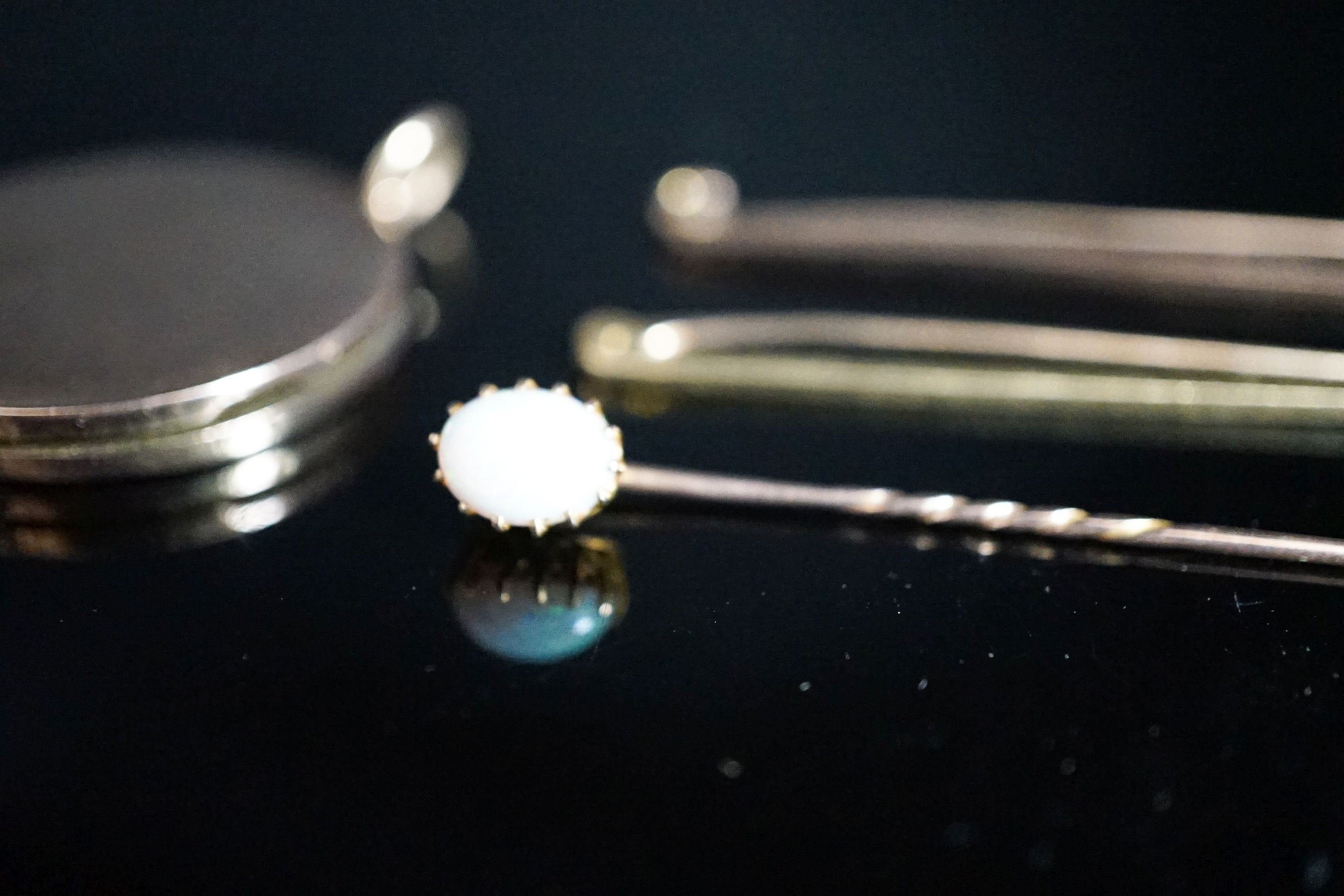 An 18ct bar brooch, 50mm, 2 grams, a 9ct bar brooch, 1.8 grams, a white opal set stick pin and a yellow metal locket.